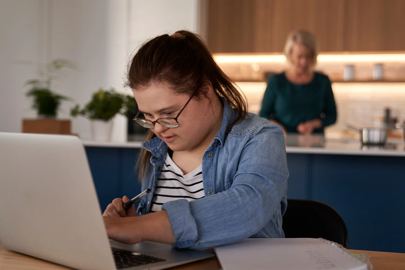 Disabled girl with down syndrome using laptop at home